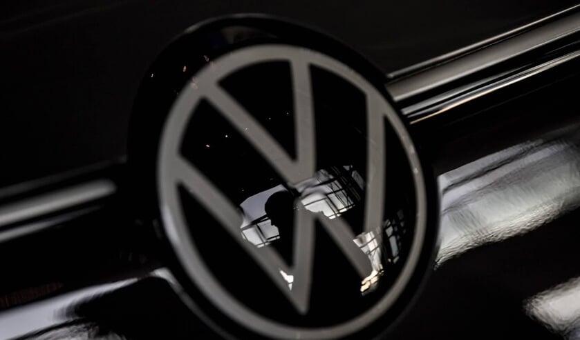 2019-11-19 13:30:29 epa08008734 A visitor is seen through a Volkswagen (VW) logo at Volkswagen Glaeserne Manufaktur (Transparent Factory) in Dresden, Germany, 19 November 2019. The German car automaker Volkswagen plans to invest 60 billion euros to switch ( beeld anp)