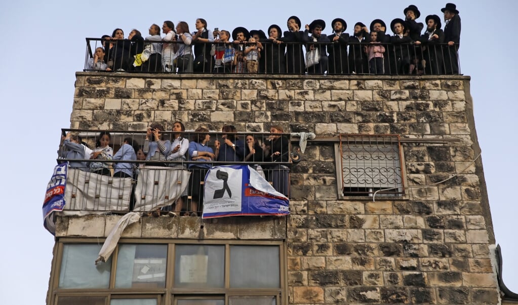 Orthodoxe Joden kijken toe bij een verkiezingsbijeenkomst in Jeruzalem. ( beeld afp / Menahem Kahana)