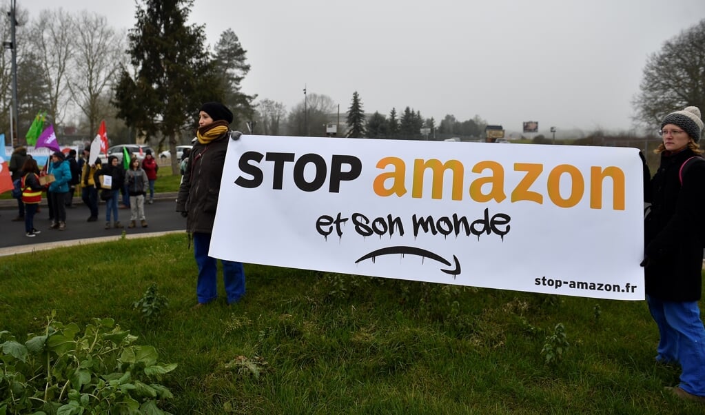 Demonstranten protesteren in de Franse plaats Augny tegen de komst van een magazijn van Amazon. Eigenaar Jeff Bezos ligt onder vuur vanwege de slechte arbeidsomstandigheden en een ontoereikend klimaatbeleid. (beeld afp / Jean-Christophe Verhaegen)