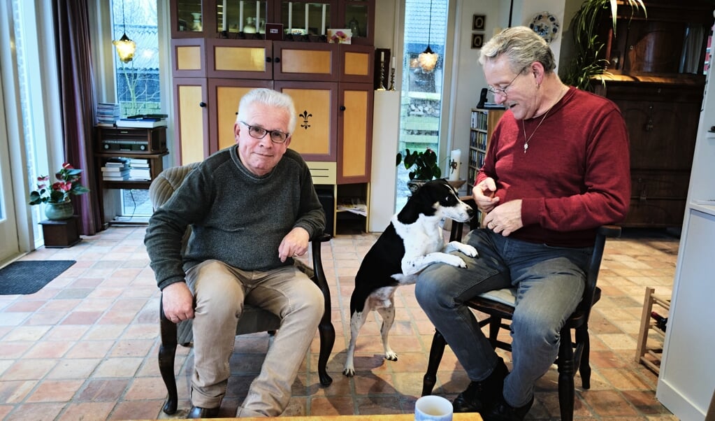 Pleegvaders Rik Laernoes (links) en Adriaan Rodenburg met hun hond Fonz, de grote liefde van John, die zelf niet op de foto wilde. Een verhaal over hem vond hij best. (beeld Dick Vos)