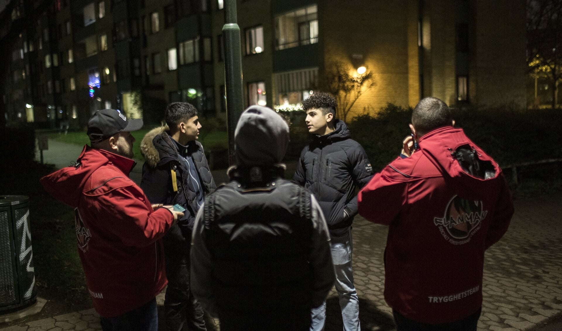 Jeugdwerkers in gesprek met jongens die op straat rondhangen. Ze zijn van de sociëteit Flamman. Die verschillende projecten en inrichtingen in de buitenwijken van Malmö heeft.