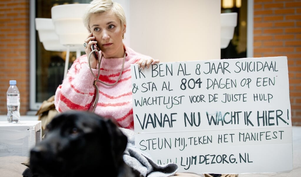 Charlotte Bouwman protesteert tijdens Blue Monday in de hal van het ministerie van Volksgezondheid, Welzijn en Sport tegen de wachtlijsten in de GGZ. (beeld anp / Sem van der Wal )