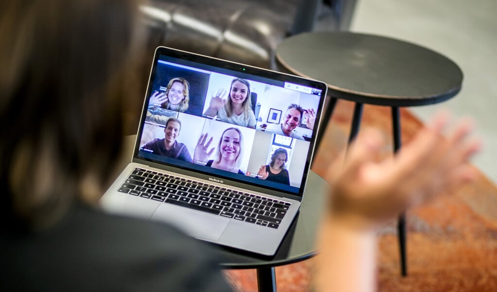 Een werknemer tijdens een videogesprek op kantoor. Vanwege de coronacrisis werken steeds meer mensen vanuit huis. (beeld anp / Remko de Waal)