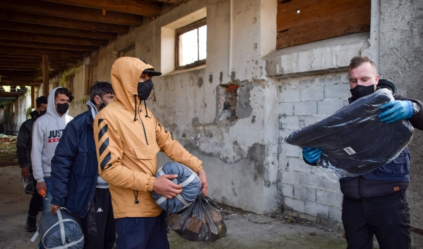 Lokale werknemers van de IOM delen eten en kleding uit aan vluchtelingen buiten de kampen.