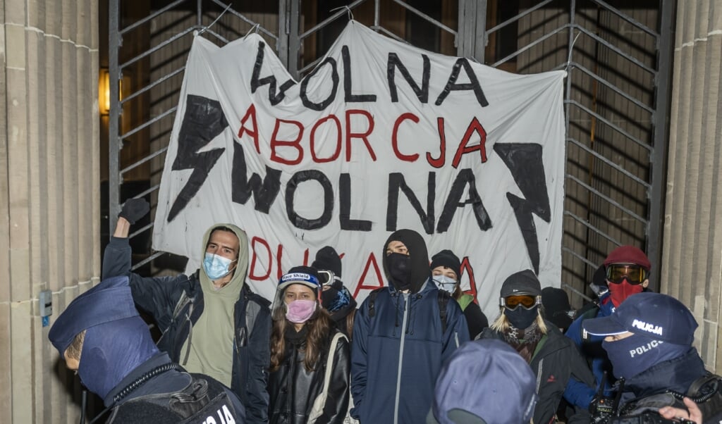 De politie greep maandag in bij een protest van pro-abortusbetogers voor het ministerie van Onderwijs in Warschau.  (beeld afp / Wojtek Radwanski)