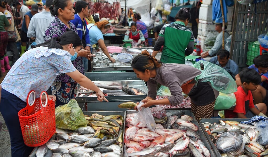 Op de Orussey-markt in het centrum van Phnom Penh drommen de mensen als vanouds samen. (beeld afp / Tang Chhin Sothy)