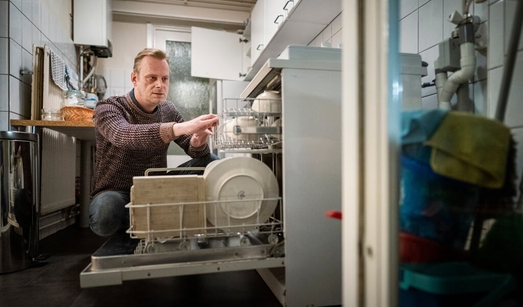 Erik Jaspers in zijn woning in Maastricht. Hij werkt als callcentermedewerker voor een minimum loon. (beeld Freek van den Bergh)