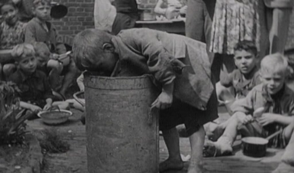 Een jongetje zoekt naar eten. Still uit de film Oorlog in Den Haag - Gefilmd Verleden 1940-1945 (beeld Haags Gemeentearchief)