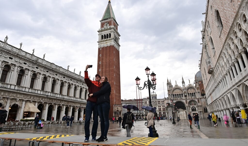 Toeristen nemen een selfie op het San Marcoplein in Venetië.   (beeld Miguel Medina / afp)