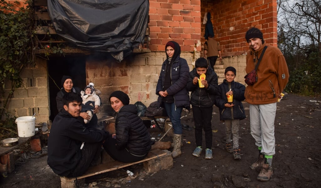 Vahid (rechts) met zijn familie voor het huis in Bosanska Bojna waar ze onderdak gevonden hebben. (beeld Marjolein Koster)