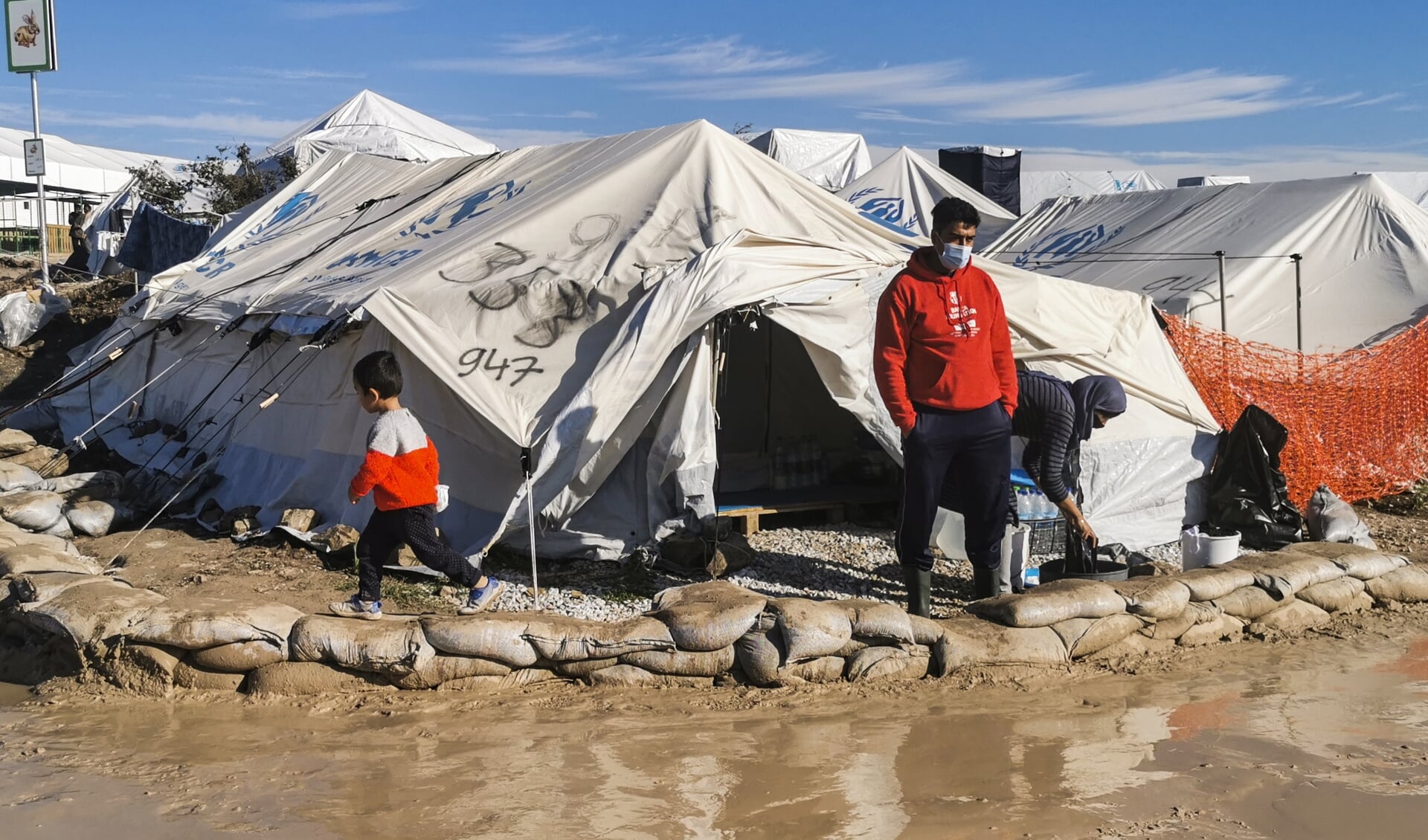 Een vluchteling voor zijn tent in het nieuwe vluchtelingenkamp op Lesbos.