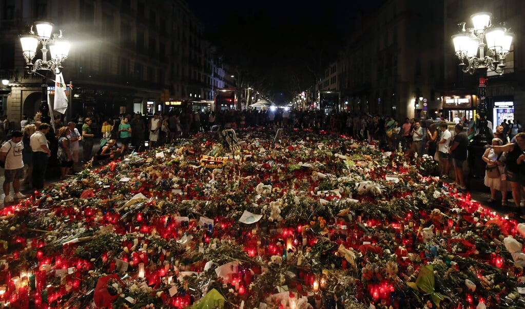 Mensen brengen bloemen, boodschappen en kaarsen om hun medeleven te betuigen met de slachtoffers van de aanslagen in Barcelona en Cambrils, en de nabestaanden. De foto is gemaakt in 2017, kort na de aanslagen.  (beeld afp / Pau Barrena)