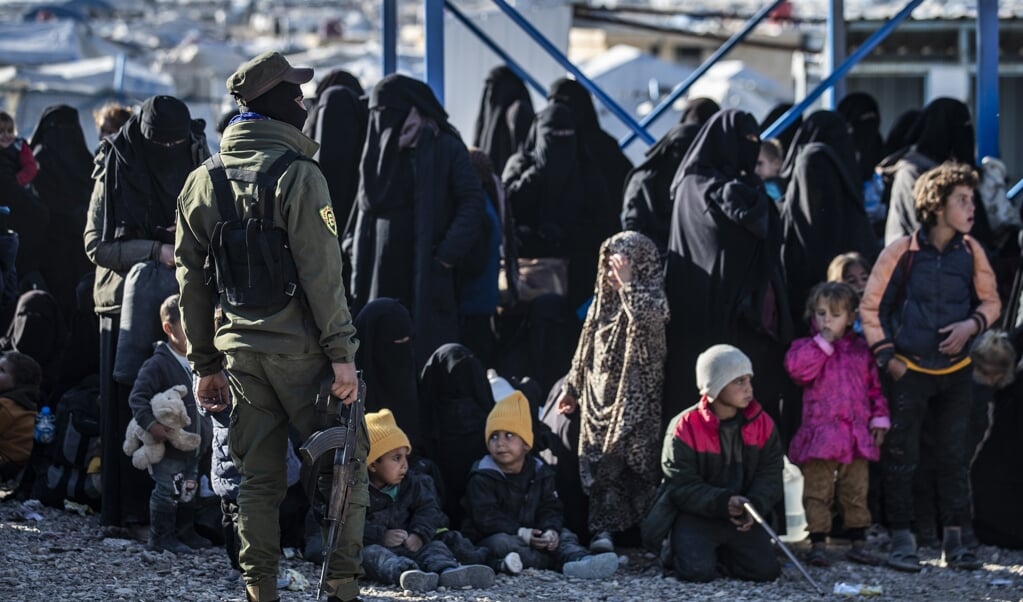 Een Koerdische bewaker bij leden van ISIS-gezinnen die worden vrijgelaten. In  de kampen al-Roj en al-Hol verblijven volgens de Finse regering nog driehonderd ISIS-vrouwen en zeshonderd kinderen uit lidstaten van de EU.  (beeld AFP/Delil Souleiman)