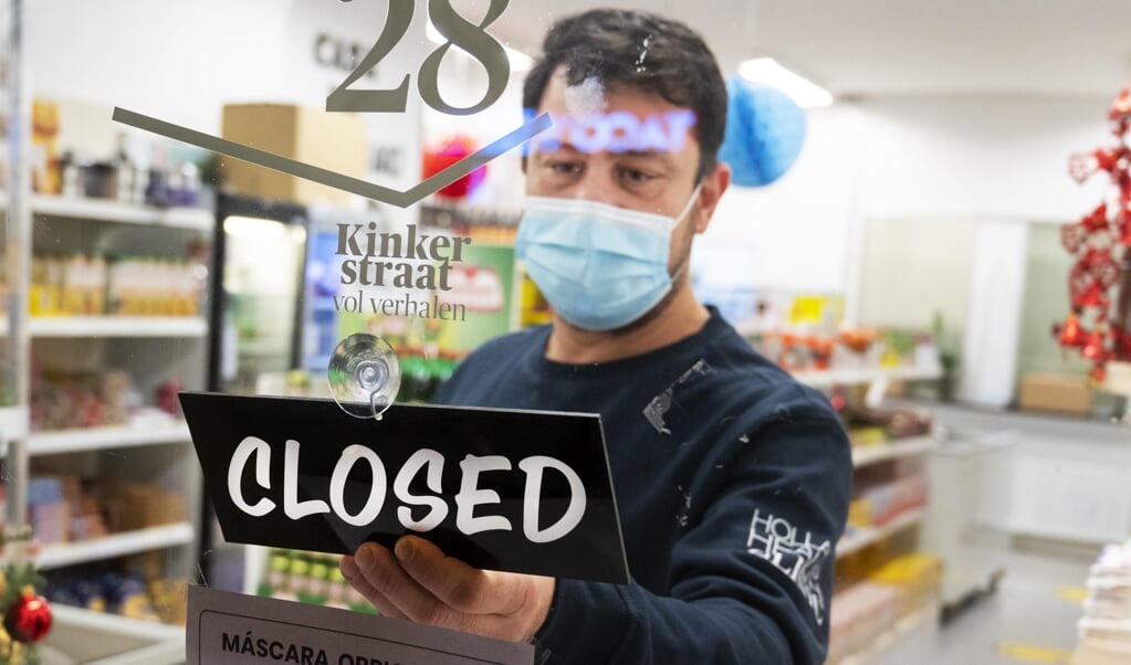 AMSTERDAM - Een winkelier sluit zijn zaak. Het kabinet wil winkels, scholen en contactberoepen sluiten om een einde te maken aan de forse stijging van het aantal nieuwe coronabesmettingen. ANP EVERT ELZINGA (beeld anp / Evert Elzinga)