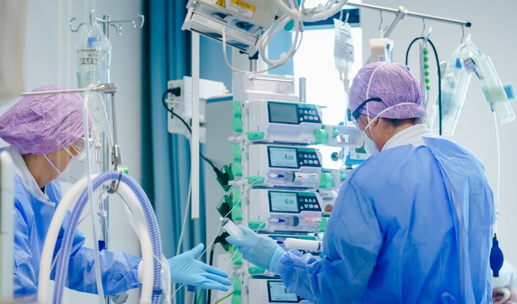 Medewerkers geven zorg aan een coronapatient op de Intensive Care afdeling. (beeld anp / Marco de Swart)