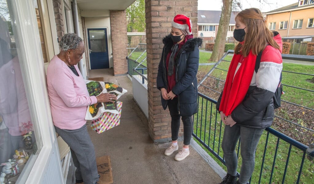 De tachtigjarige Dorothy Kingsale bekijkt de inhoud van de verrassingstas van Sahla Lograda en Joy de Blok. (beeld Hans-Lukas Zuurman)