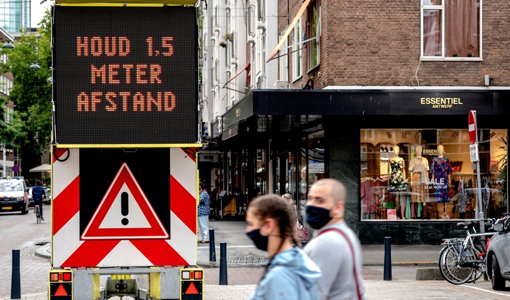 Een bord met informatie over mondkapjesplicht tegen het coronavirus in het centrum van Rotterdam. (beeld anp / Sander Koning)