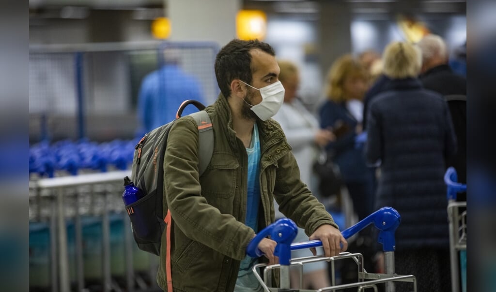 Nederlandse passagiers van het cruiseschip de Westerdam arriveren op Schiphol. De Nederlanders zijn negatief getest op het coronavirus en mochten daarom terug naar Nederland. (beeld anp / Michel van Bergen)