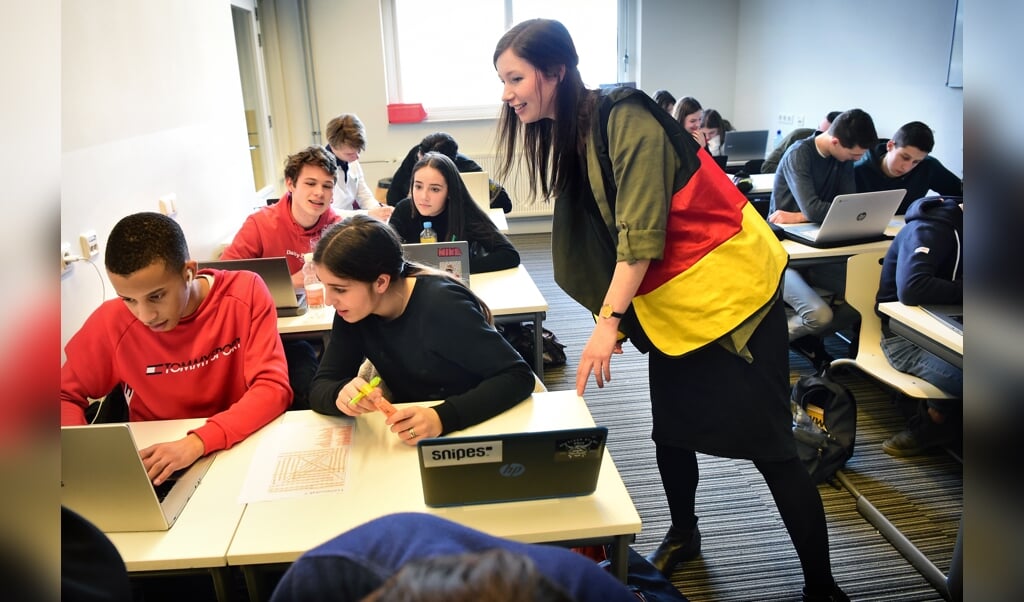 Duitse les aan havo-5-leerlingen op het Odulphuslyceum in Tilburg. Wanneer docent Annika Horijon haar hesje met de Duitse vlag draagt, mogen de leerlingen geen Nederlands spreken. (beeld Marcel van den Bergh)