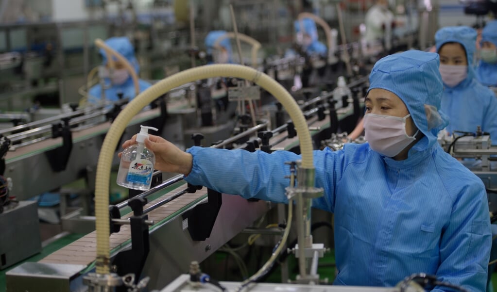 Een arbeider controleert de productie van flesjes desinfecterende vloeistof in zeepfabriek Ryongaksan in de Noord-Koreaanse hoofdstad Pyongyang. (beeld afp / Kim Won Jin)