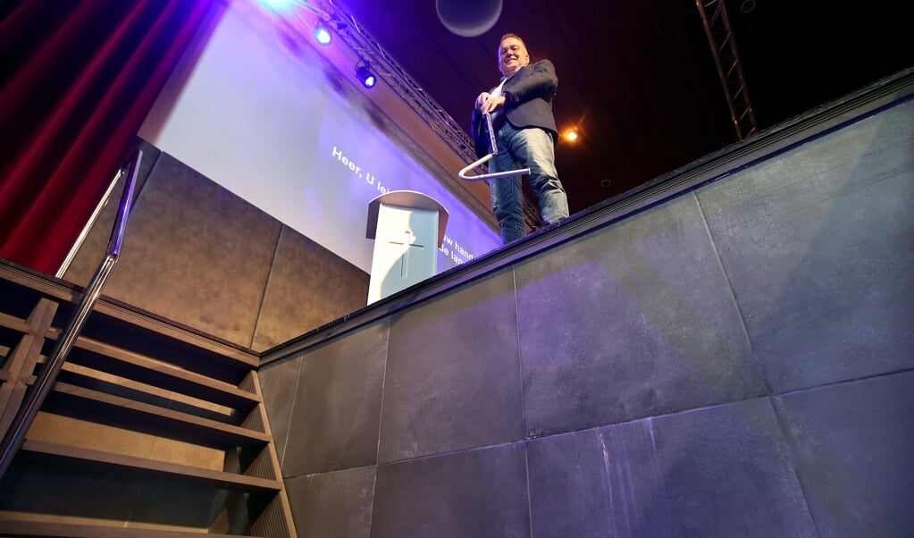 Dominee Gerke Oostra met zijn attribuut voor de doop op anderhalve meter afstand ten tijde van corona. (beeld persburo Melissen)