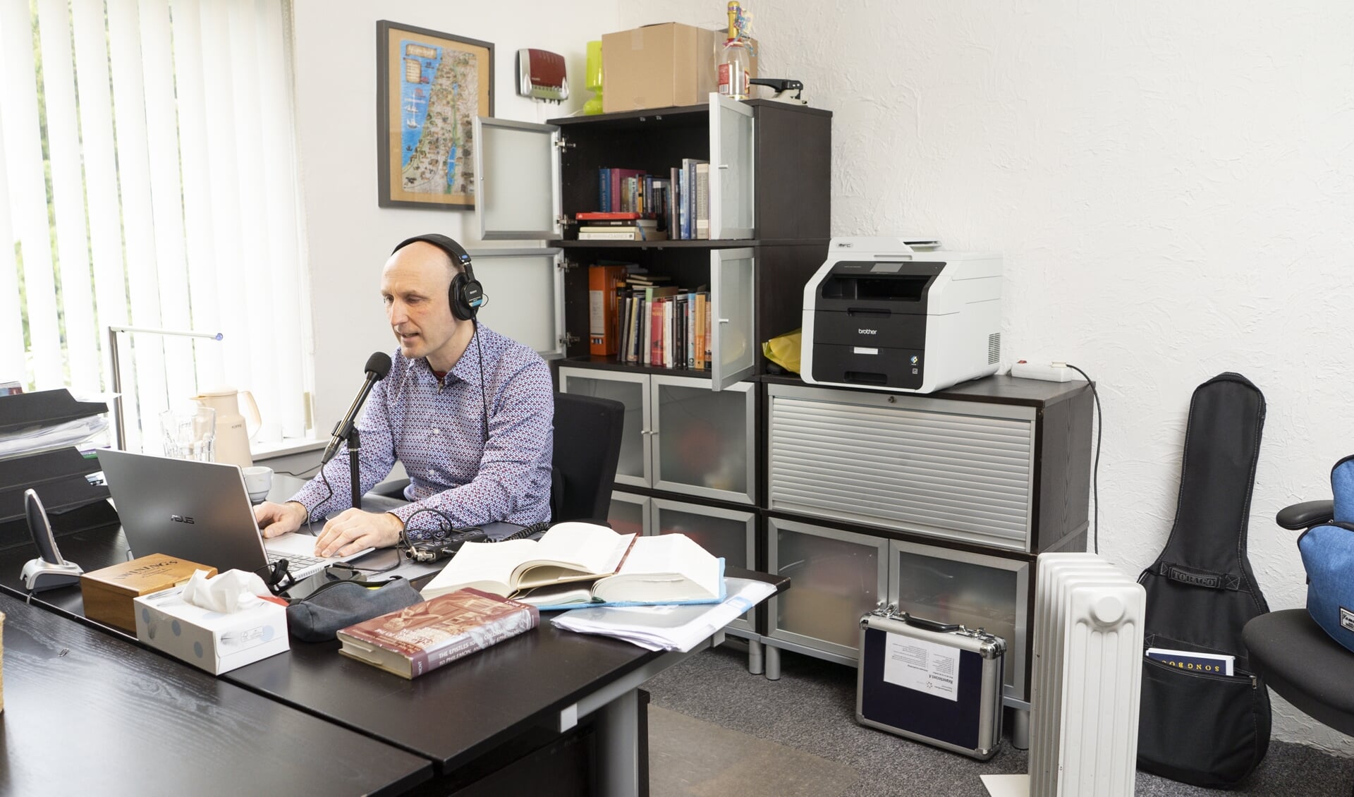 Hans Alblas op zijn werkplek in het kantoorpand van Stichting Echo in Harderwijk.