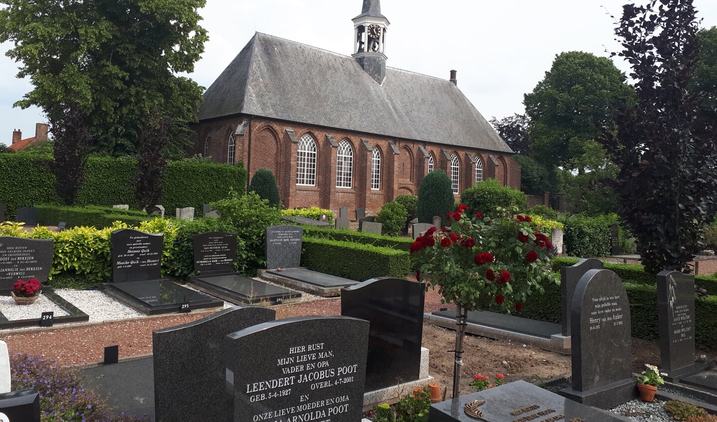 De begraafplaats in Hedel en de Nederlands-hervormde kerk met zijn witte houten torentje.