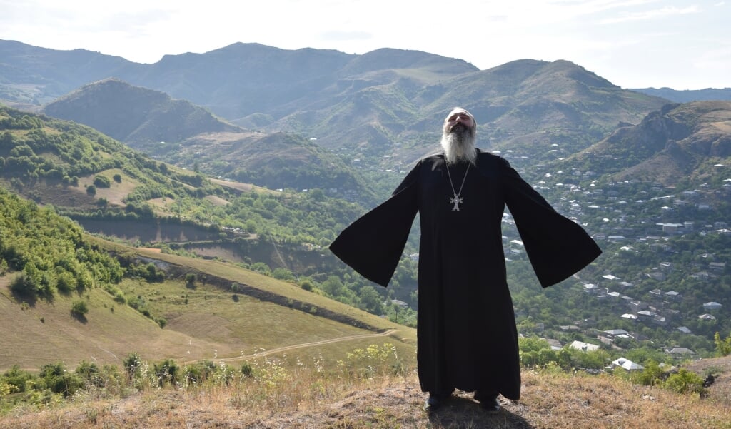Een priester bidt voor vrede in het plaatsje Movses, op de grens tussen Armenië en Azerbeidzjan, nadat bij grensconflicten zeker 16 mensen om het leven kwamen. (beeld afp / Karen Minasyan)