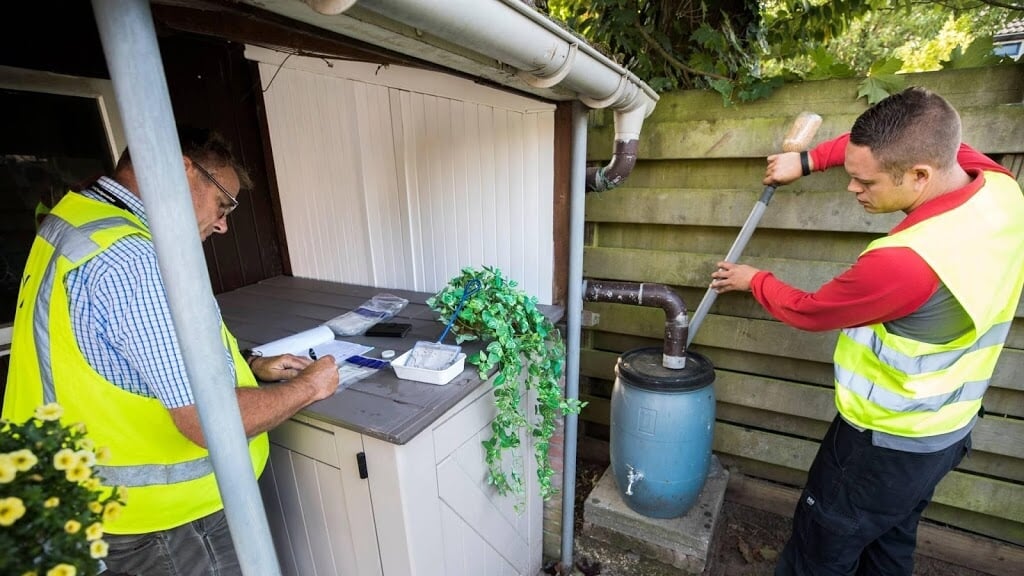 Medewerkers van de NVWA controleren in een tuin in Aalten alle plekken waar de mug eitjes gelegd kan hebben. 