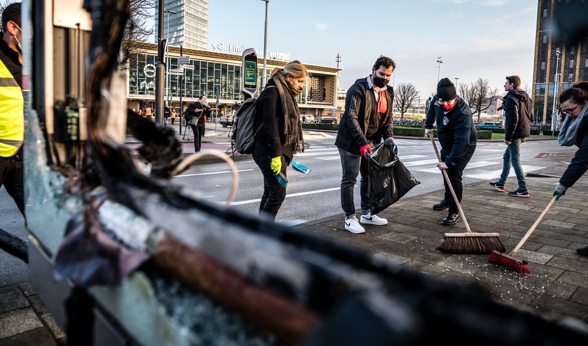 Vrijwilligers helpen in het centrum van Eindhoven bij het opruimen van de schade, na de rellen van afgelopen zondag.