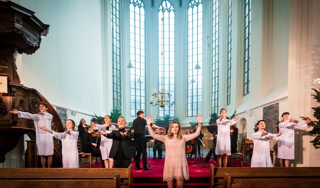 Almatine Leene, de Theoloog des Vaderlands, met achter en naast haar de dansers van de Dutch Don’t Dance Division en de leden van het Kloosterkerk-Ensemble en Collegium Delft onder leiding van dirigent Daniel Rouwkema. (beeld eo / Willem Jan de Bruin)