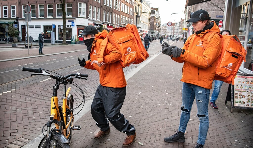 Twee bezorgers van Thuisbezorgd.nl gaan op pad met hun bestelling.  (beeld Guus Dubbelman)
