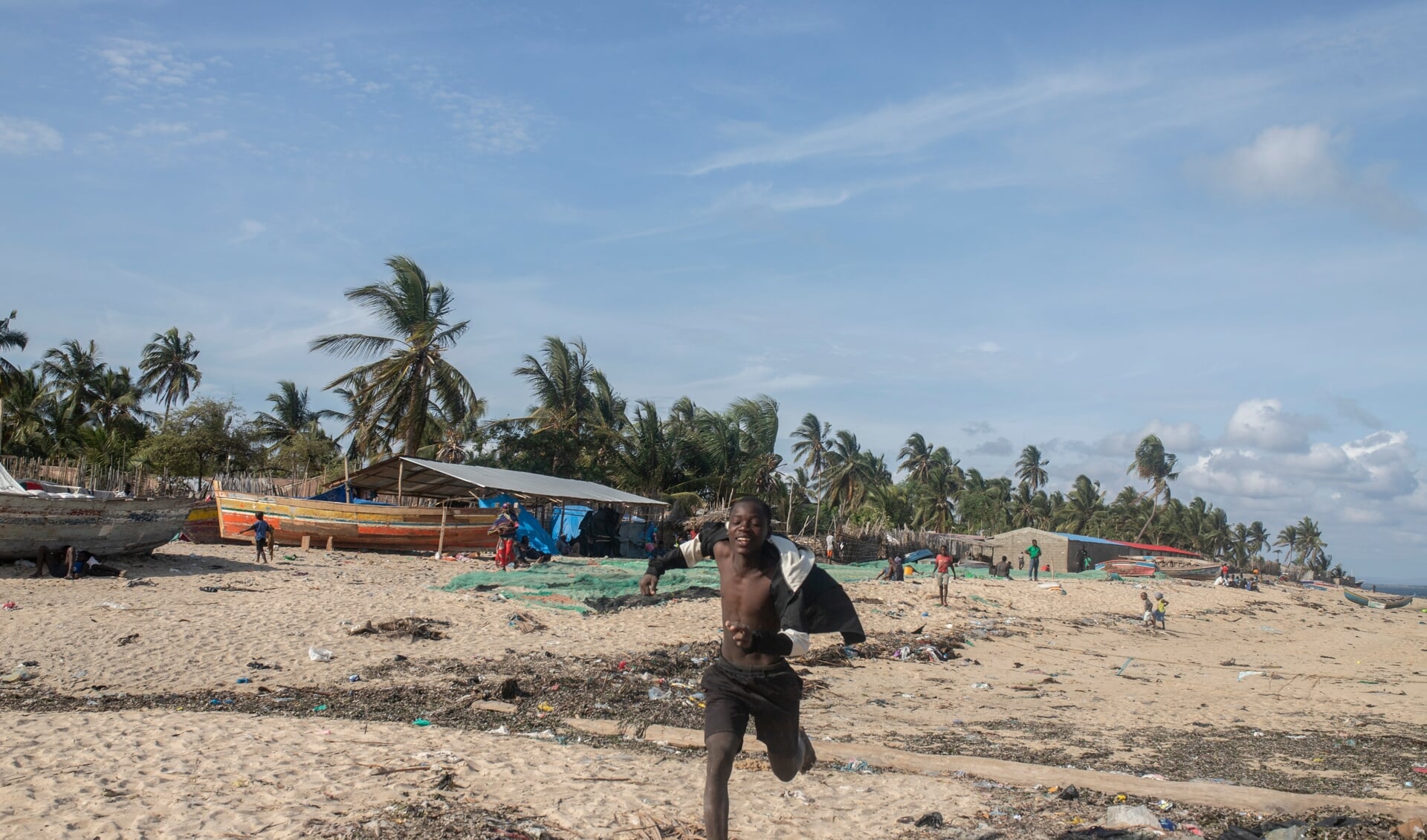 Een jonge man rent over het strand van Paquitequete in Pemba. Op deze plaats kwamen de afgelopen maanden duizenden vluchtelingen aan.