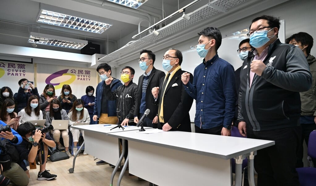 Alan Leong, voorzitter van de Burgerpartij (derde van rechts), en andere leden schreeuwen slogans tijdens de persconferentie in Hongkong, na de arrestatie van tientallen oppositieleden.  (beeld afp / Anthony Wallace)