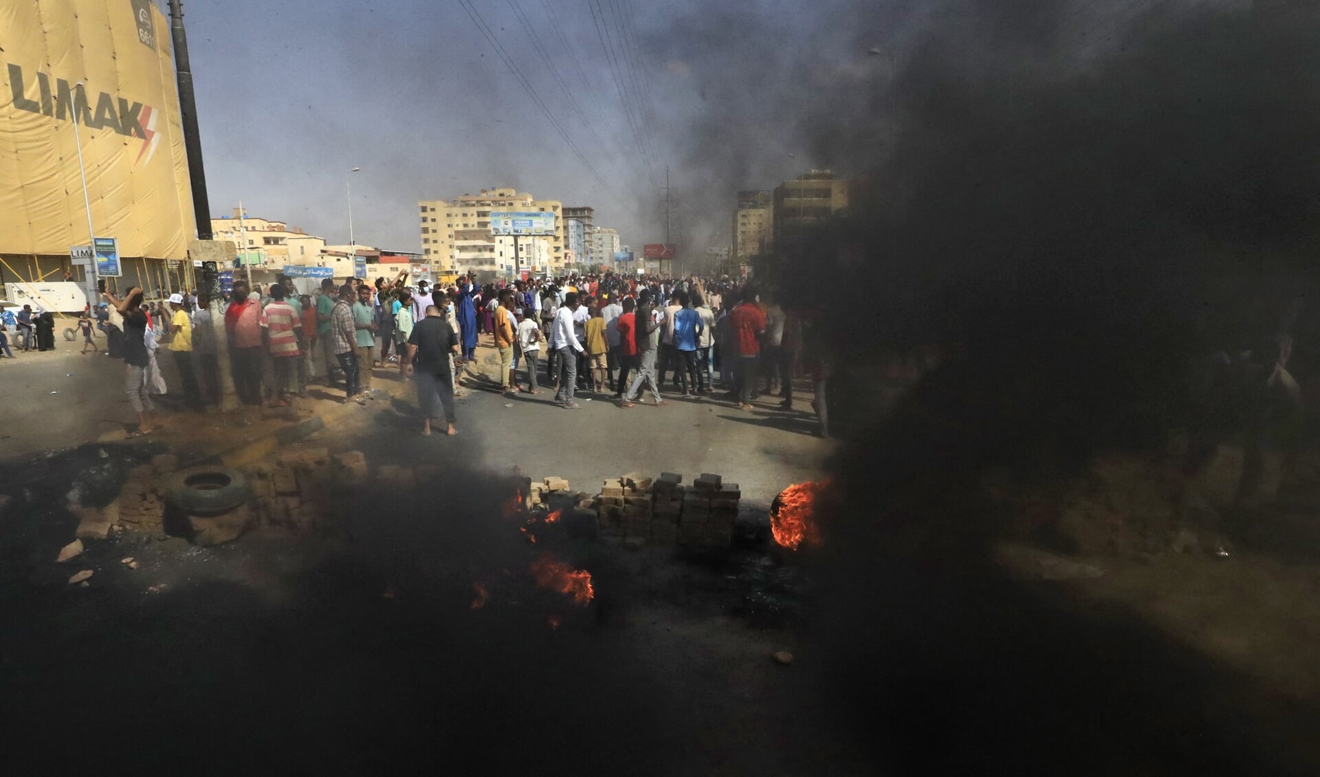 Sudanese demonstranten gooien met stenen en verbranden autobanden om in Khartoem de weg te blokkeren.