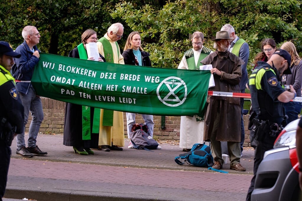 De politie haalde een groep voorgangers over de rijweg te verlaten en op de stoep te gaan staan waar zij in gebed gingen. (beeld Dirk Hol)