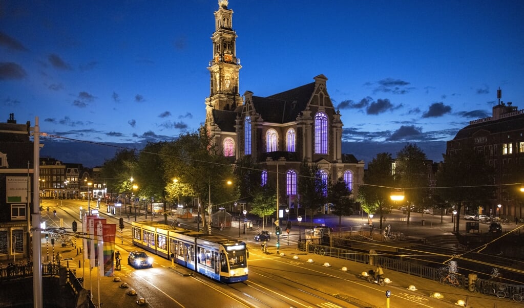 Vragen rekening te houden met jonge lhbti'ers in kwetsbare posities, is geen aanval op christelijke waarden. Beeld: de Westerkerk in Amsterdam werd eerder dit jaar verlicht in regenboogkleuren. (beeld anp / Ramon van Flymen)