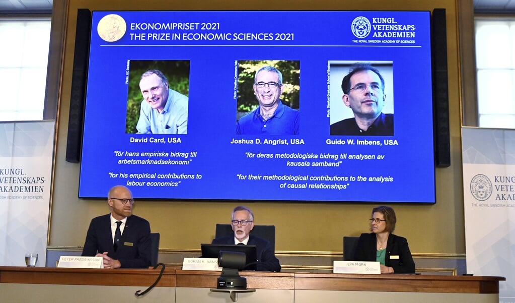 Goran K Hansson (C), Peter Fredriksson (L) en Eva Mork (R) leden van de Koninklijke Zweedse Academie van Wetenschappen, kondigen de winnaar van de Nobelprijs voor economie aan. (beeld epa / Claudio Bresciani)