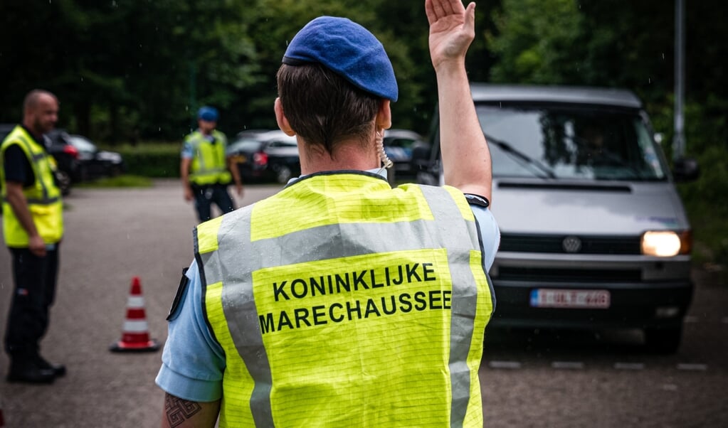 De Koninklijke Marechaussee controleert reizigers langs de A67 aan de grens met België. (beeld anp / Rob Engelaar)