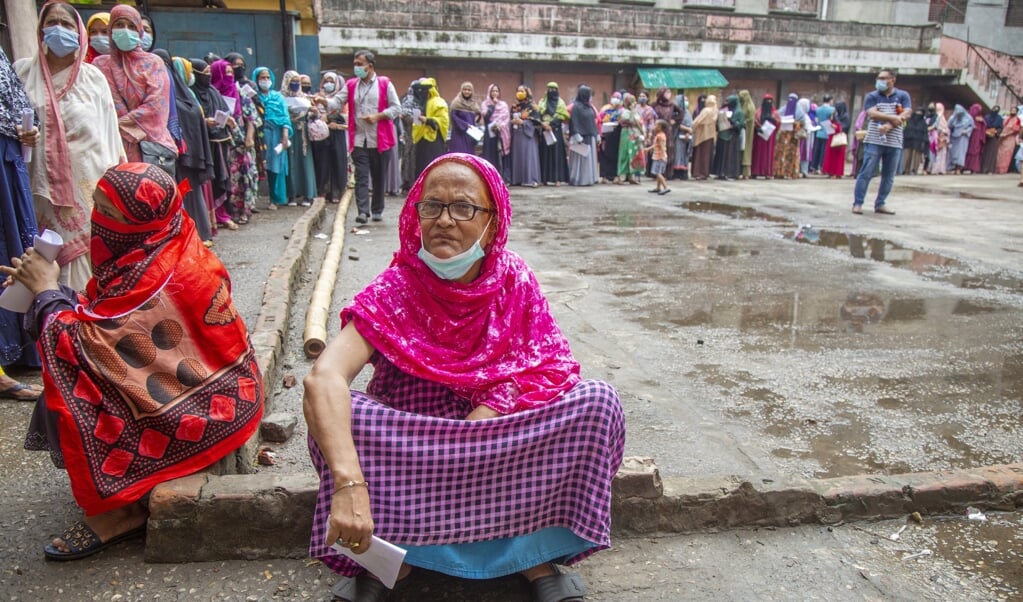 In de rij voor een prik met het Sinopharm-vaccin in Dhaka, Bangladesh. Dat Chinese vaccin bleek lang niet zo effectief als aanvankelijk was verteld. (beeld epa / Monirul Alam)