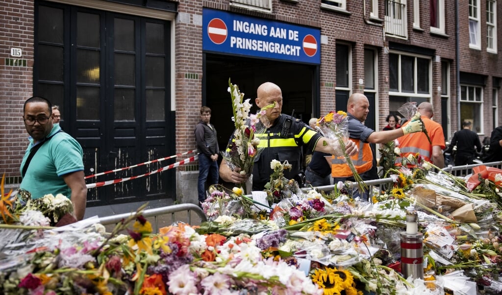 2021-07-23 12:35:24 AMSTERDAM - Een medewerker van de gemeente ruimt bloemen en kaartjes op voor Peter R. de Vries in de Lange Leidsedwarsstraat. De misdaadverslaggever overleed aan zijn verwondingen op 64-jarige leeftijd nadat hij werd neergeschoten. Kaartjes en andere persoonlijke boodschappen worden bewaard en later aan de familie van De Vries gegeven. ANP RAMON VAN FLYMEN (beeld anp / Ramon van Flymen)