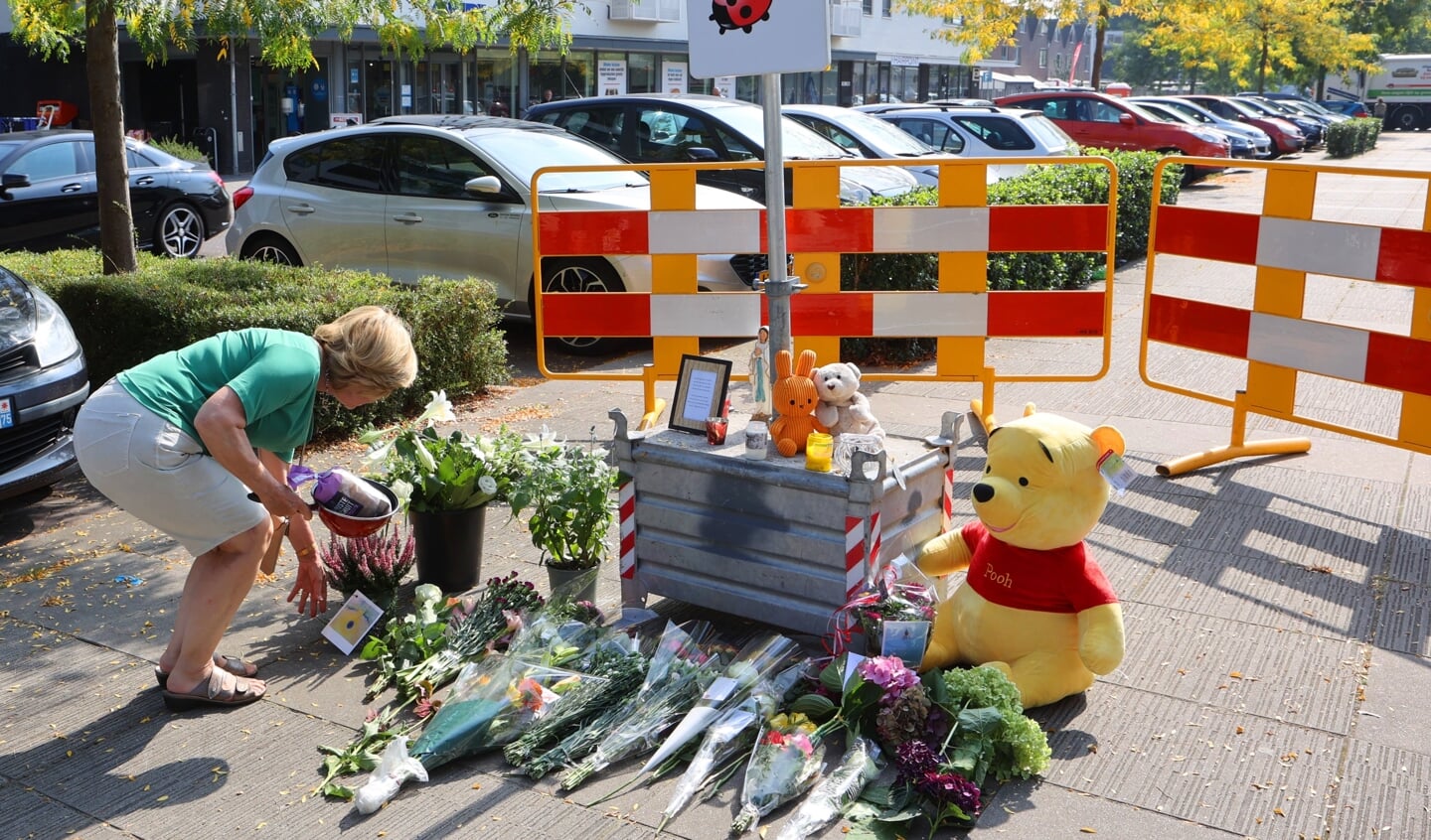 Een vrouw in Den Bosch legt bloemen op de plek waar een 34-jarige vrouw om het leven is gekomen door een steekpartij. 