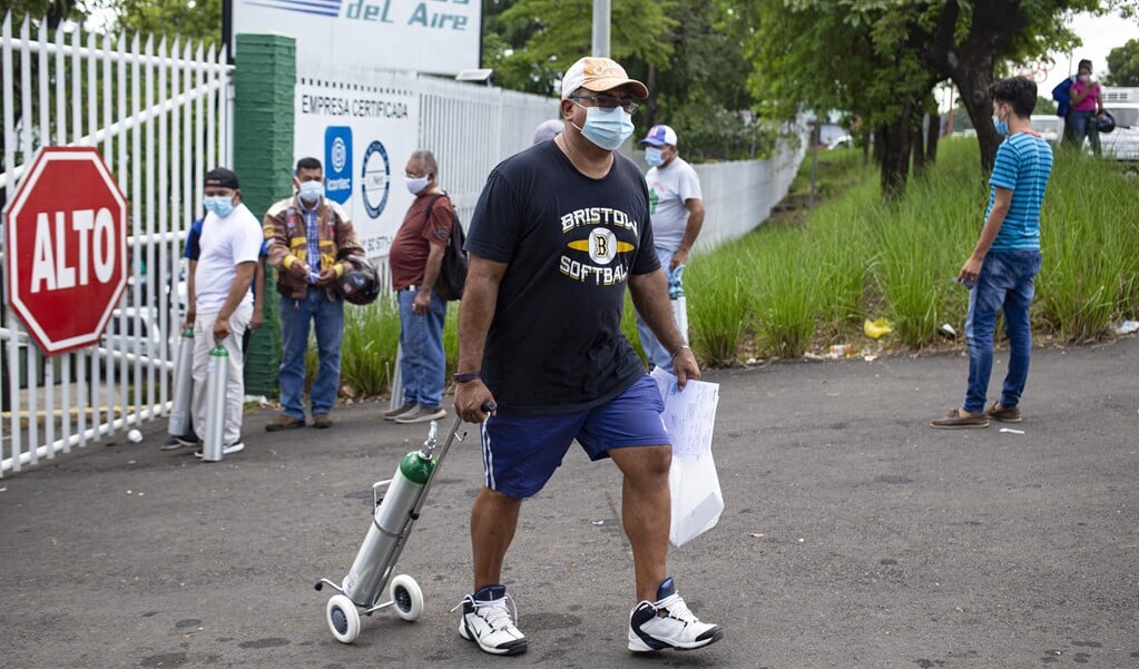 Een man in Nicaragua trekt een zuurstoftank achter zich aan om bij te vullen bij een zuurstoffabriek. (beeld afp / Oswaldo Rivas)