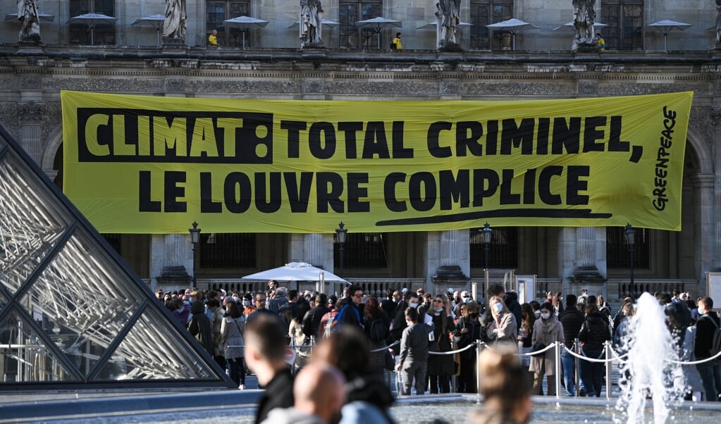 Greenpeace voert in Parijs actie tegen het beleid van oliemaatschappij Total.  (beeld afp / Anne-Christine Poujoulat )