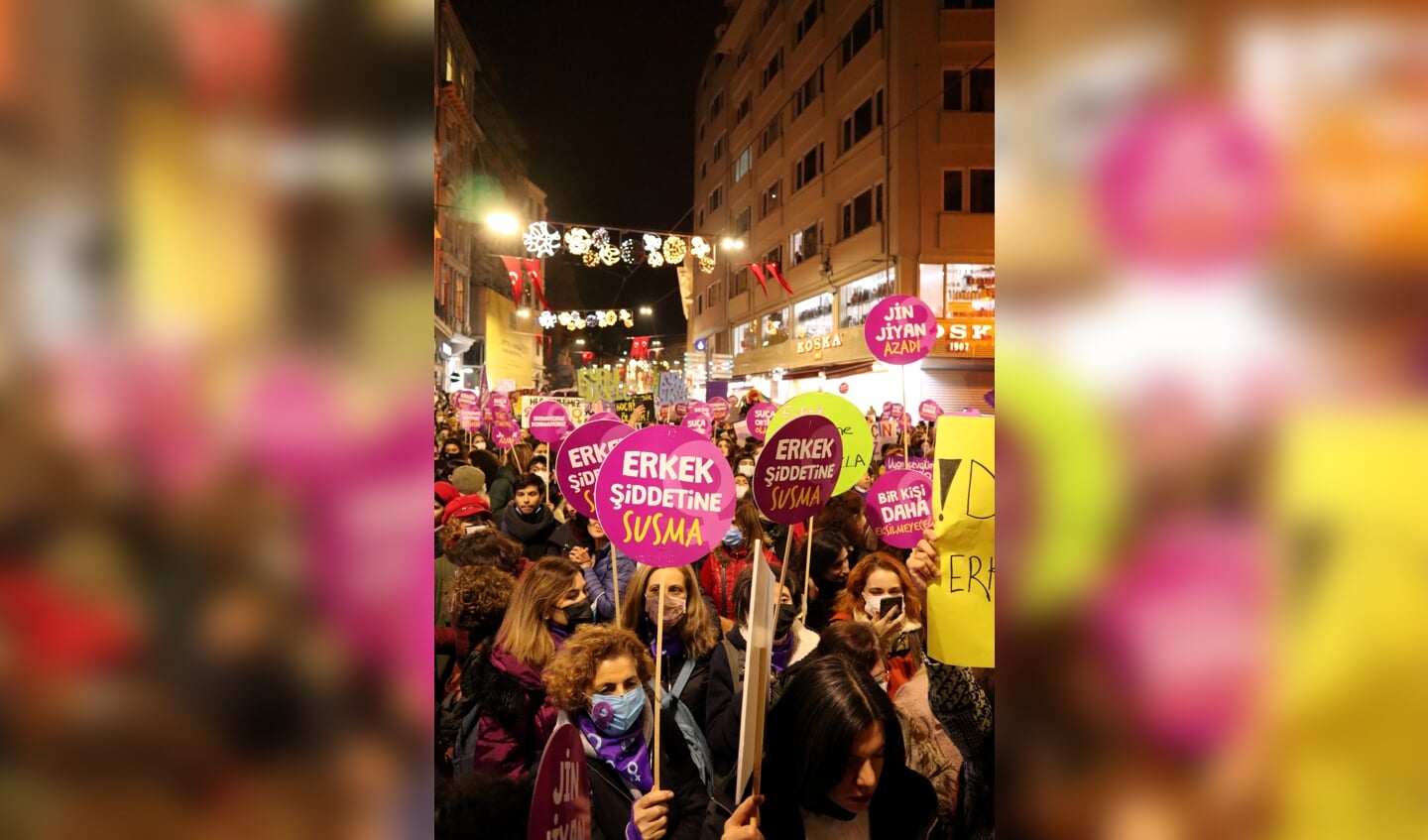 Protest op de Istiklalstraat in Istanbul. Op de roze borden in het midden staat: ‘Zwijg niet over mannelijk geweld.’