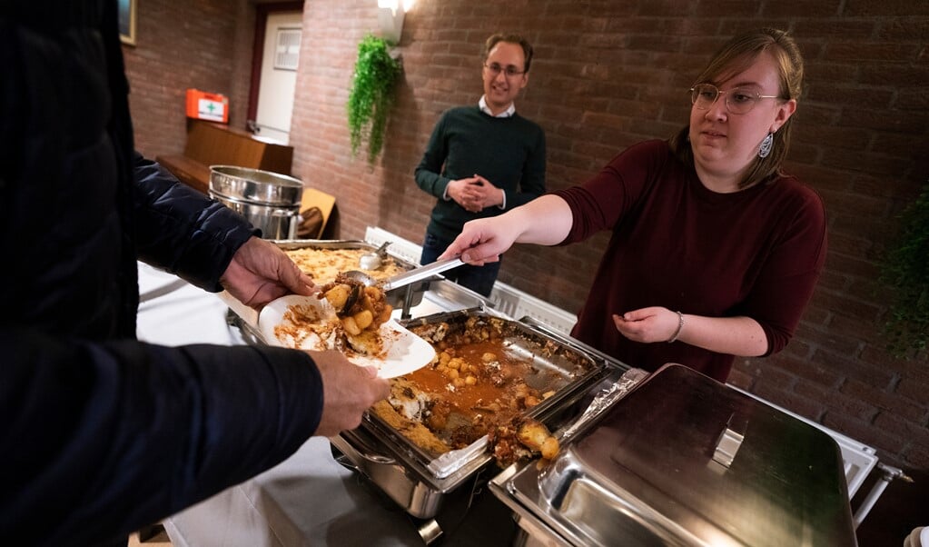Gemeenteleden Chris van Balen en Liza Hetem vinden het leuk om praktisch te kunnen helpen bij de maaltijd. (beeld Jeroen Jumelet)