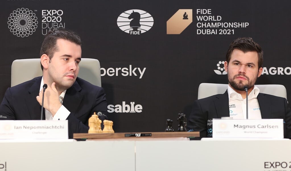 Ian Nepomniachtchi (l) en Magnus Carlsen (r) op een persconferentie voorafgaand aan het wereldkampioenschap. (beeld Epa /ali Haider)