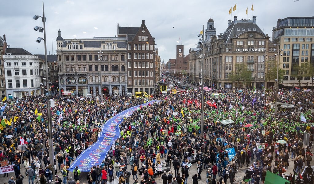 Actievoerders dragen een spandoek van Greenpeace tijdens de Klimaatmars in Amsterdam.  (beeld anp / Evert Elzinga)