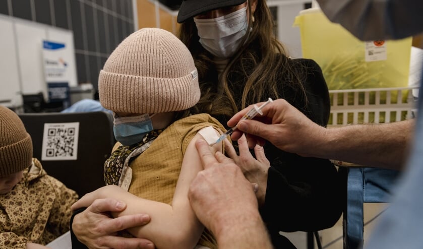 Een 7-jarige krijgt op woensdag het Pfizer-vaccin in Montreal, Canada. Ook Israël is al begonnen met het vaccineren van kinderen onder de 12. In Nederland moet de Gezondheidsraad daarover nog advies uitbrengen. (beeld afp / Andrej Ivanov)