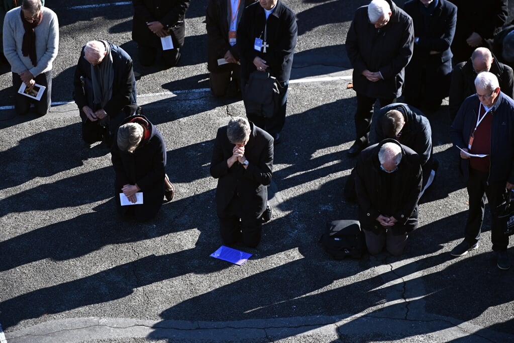 Franse bisschoppen knielen tijdens een boeteliturgie in het Franse bedevaartsoord Lourdes waarbij zij zaterdag vergeving vroegen aan de slachtoffers van seksueel misbruik. Op verzoek van de slachtoffers droegen zij geen liturgische kleding.   (beeld afp / Valentine Chapuis)